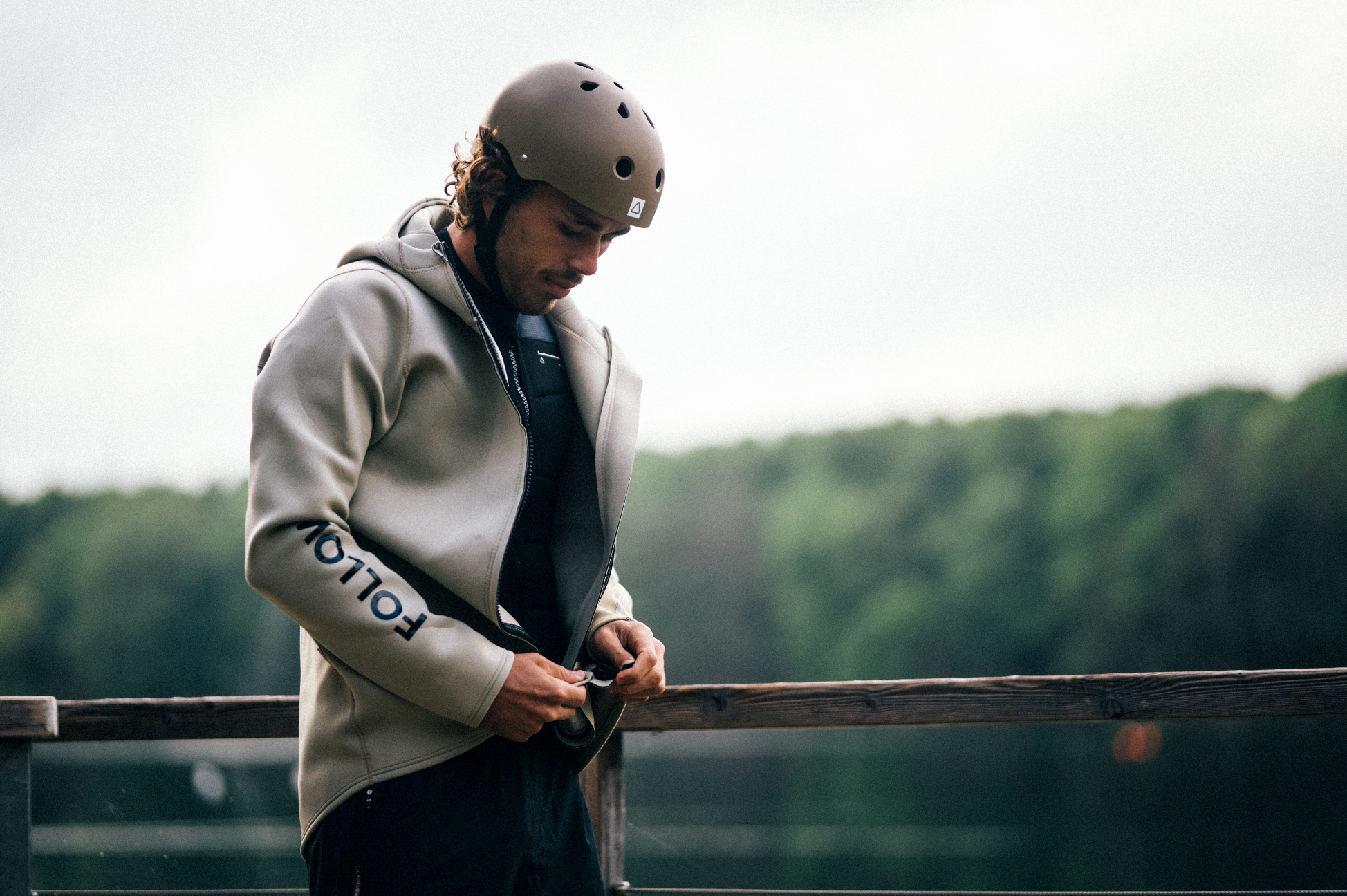 Rudy zipping up the Follow Neo jacket over his Follow impact vest for cold spring wakeboard sessions at the cablepark. Essential Spring cable park layering.