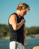 Person wearing a black weighted vest by a body of water