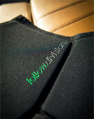 Black fabric with 'follow' logo on a beige leather surface