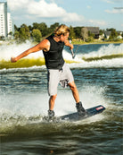 Person wakeboarding on a lake with a cityscape in the background