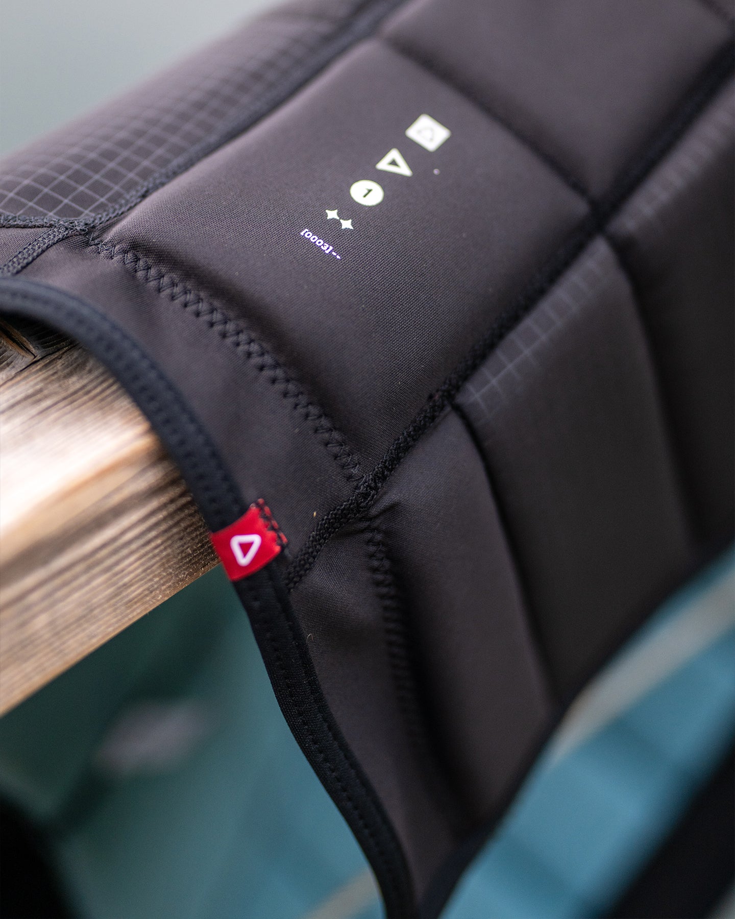 Close-up of a black protective pad with a brand logo on a wooden surface